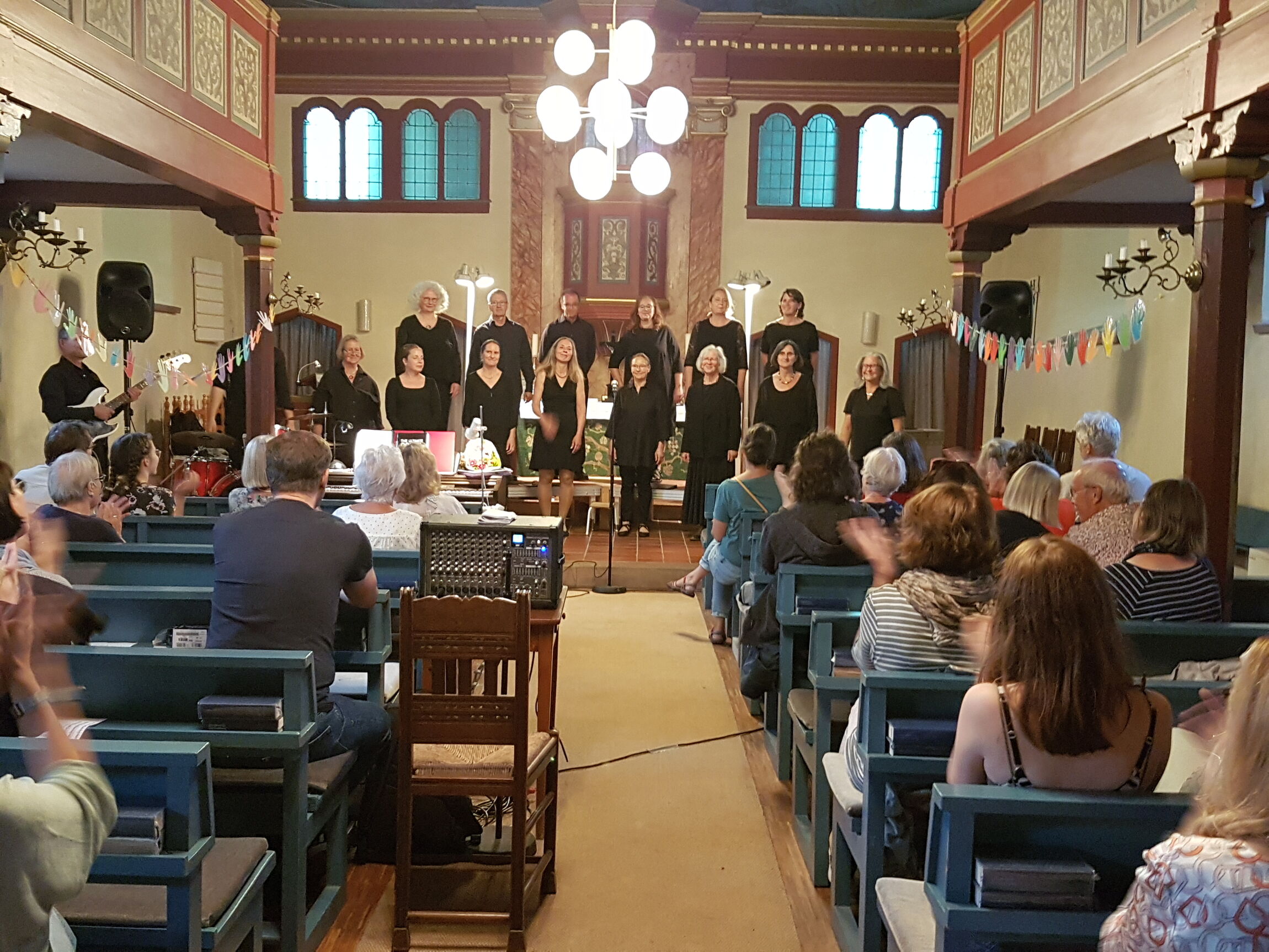 Schlussapplaus: der Chor und seine Leiterin (Foto: L. Heinke) 