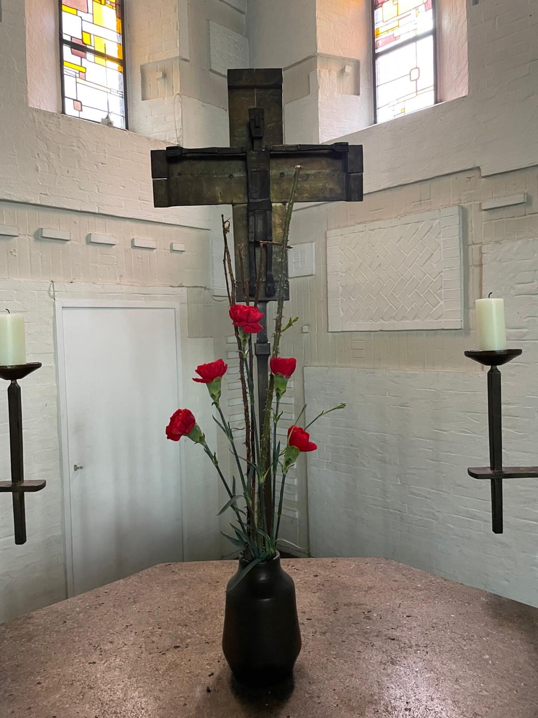 Altar an Karfreitag, Kerzen sind aus, Vase mit Nelken und Dornenzweigen