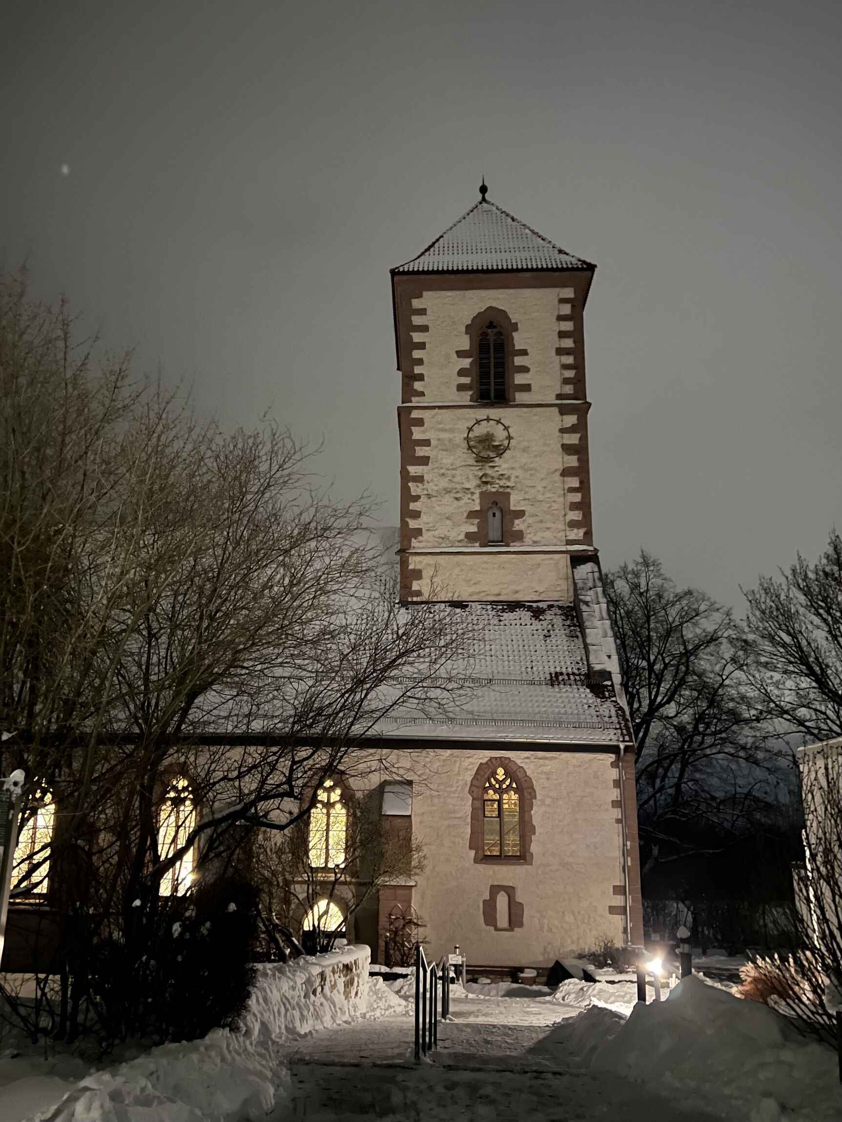 Vorderansicht der Klosterkirche Nikolausberg am Abend, beleuchtet