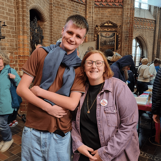 Ein jungen Mann und eine Frau lächeln in die Kamera
