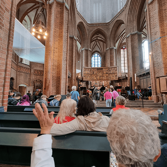 Besucherinne und Besuchern feiern in der St. Nicolai Kirche