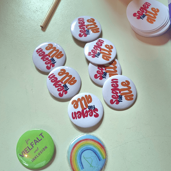 Button mit verschiedenen Motiven liegen auf einem Tisch