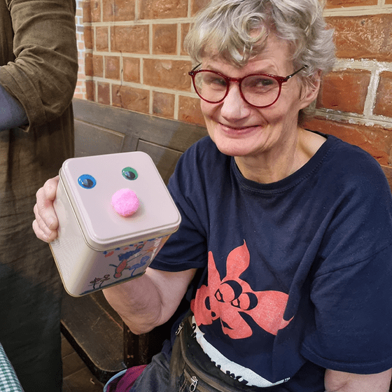 Frau mit beklebter und bemalter Dose