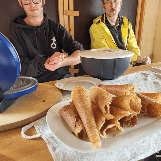 zwei Männer an einem Essensstand mit friesischen gerollten Waffeln