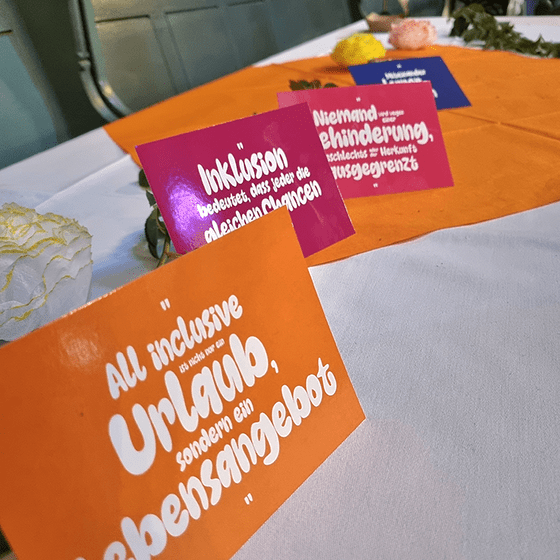 verschienfarbige Postkarten mit Sprüchen sind auf einem Tisch aufgebaut