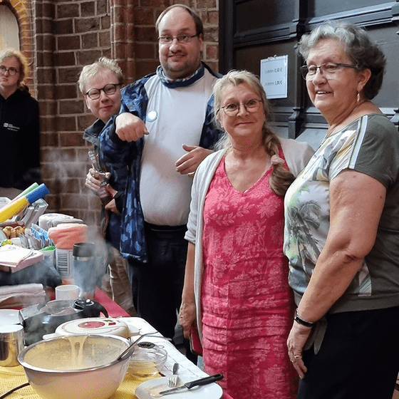 Menschen am Waffelstand lächeln in die Kamera