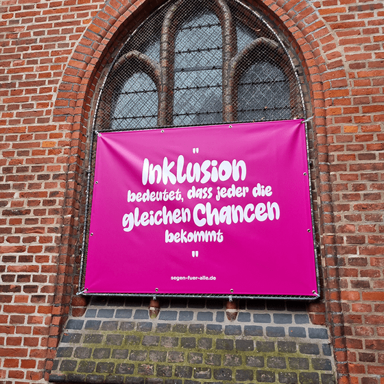 pinkes Banner mit dem Spruch "Inklusion bedeutet, dass jeder die gleichen Chancen bekommt"